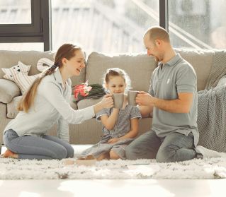 A joyful family enjoying quality time and coffee in a bright living room, symbolizing love and togetherness.