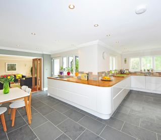 A spacious modern kitchen with elegant interiors featuring a dining table and luxurious design.
