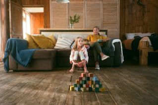 A family relaxing together with children playing with wooden blocks indoors.